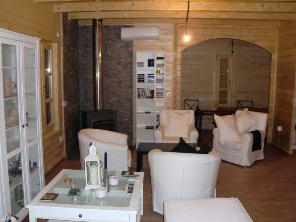 Salon de casa de madera, amueblado con muebles en blanco.